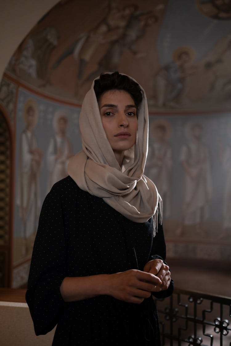 Woman Wearing Black Dress And Shawl On Head In Church Interior With Fresco