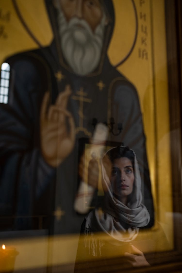 Female Face Looking With Faith Reflecting In Icon Glass