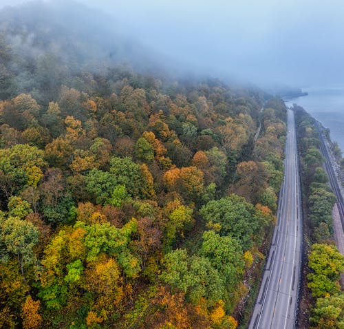 Aerial Shot of Mountain Road Near the Body of Water 