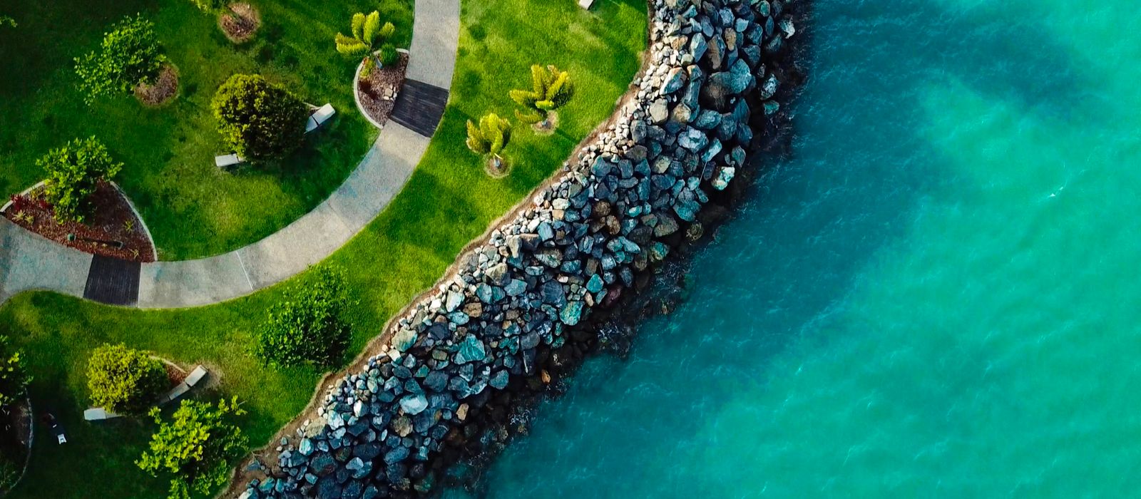 Stunning aerial view of Airlie Beach coastline in Queensland, Australia, showcasing lush greenery and turquoise waters.