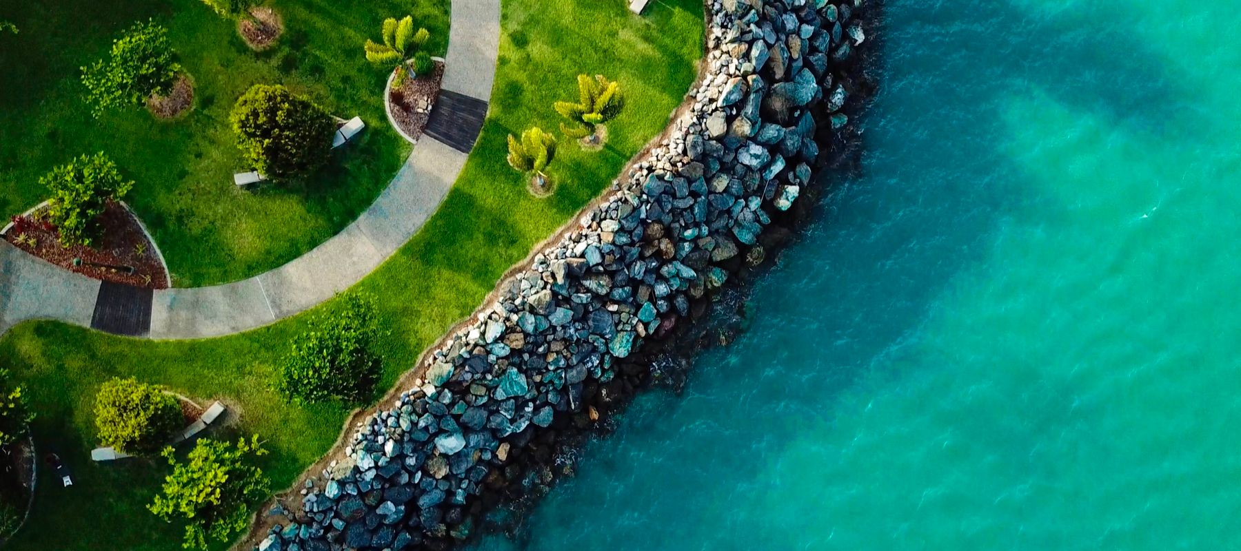 Stunning aerial view of Airlie Beach coastline in Queensland, Australia, showcasing lush greenery and turquoise waters.