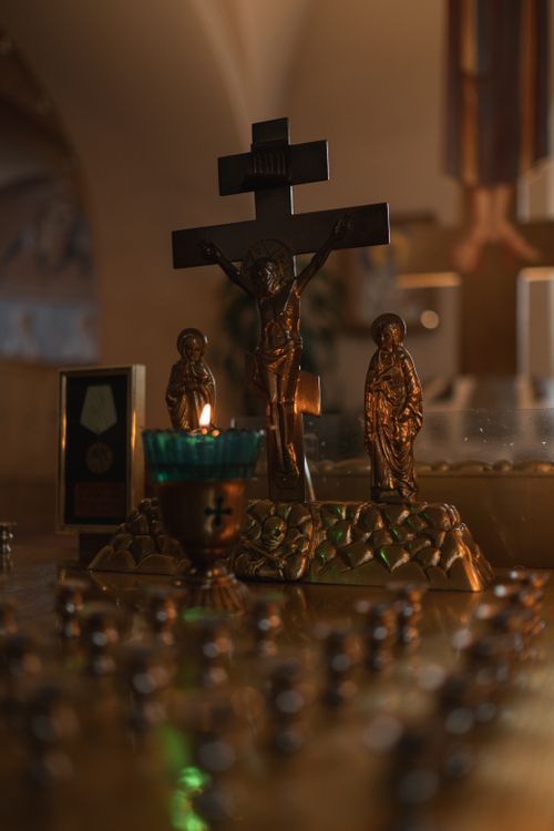 Free A dimly lit church altar with gold religious statues and a green candle accentuating the spirituality of the space. Stock Photo