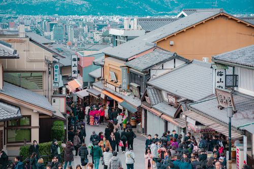 Free Crowds walk through a vibrant street in a historic Japanese town, full of traditional architecture. Stock Photo