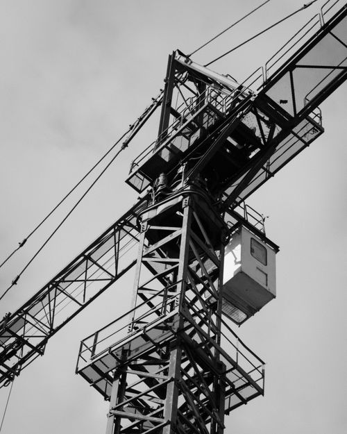 Free Detailed view of a towering steel construction crane in black and white. Stock Photo