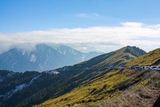 Breathtaking view of a mountain range with lush greenery under a clear blue sky.