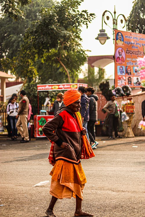 An Elderly Man Walking on the Street Barefooted