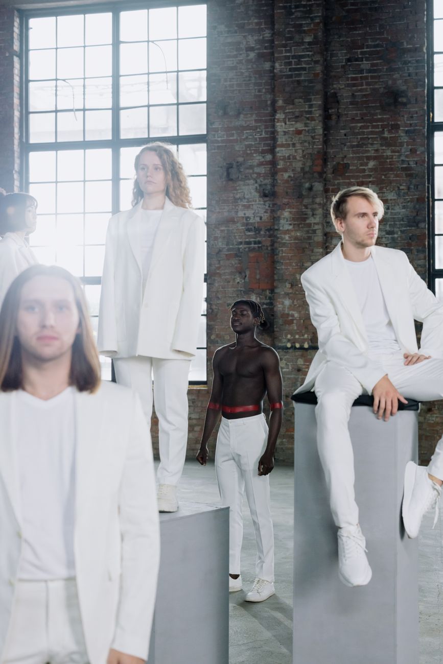 Group of diverse male and female models in a modern white attire photoshoot.