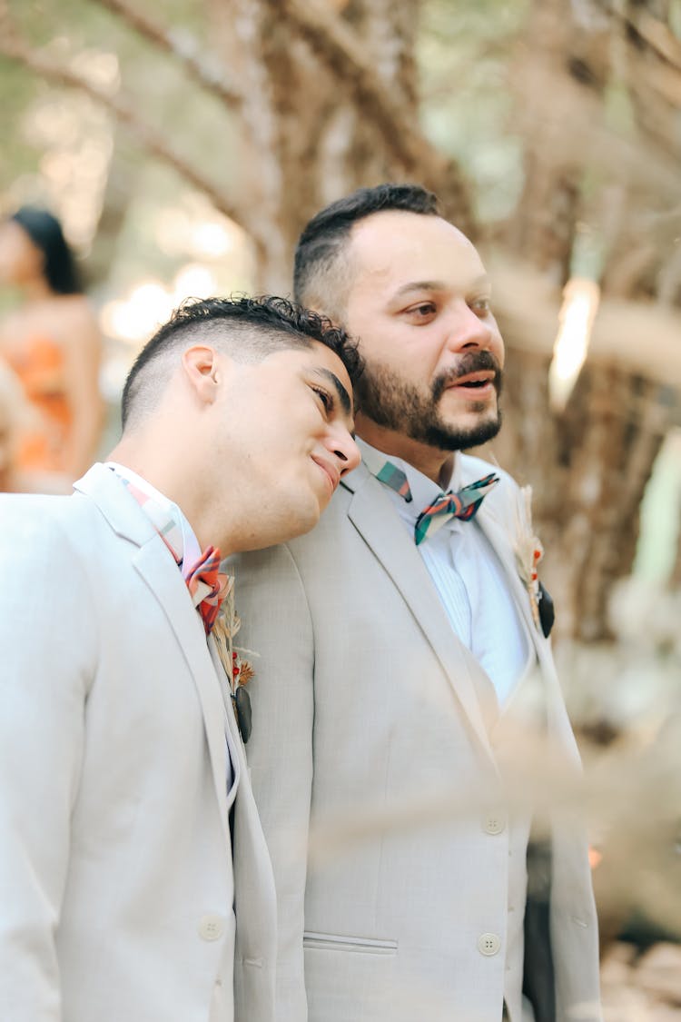 Man Wearing Suit Resting Head On Boyfriend Shoulder