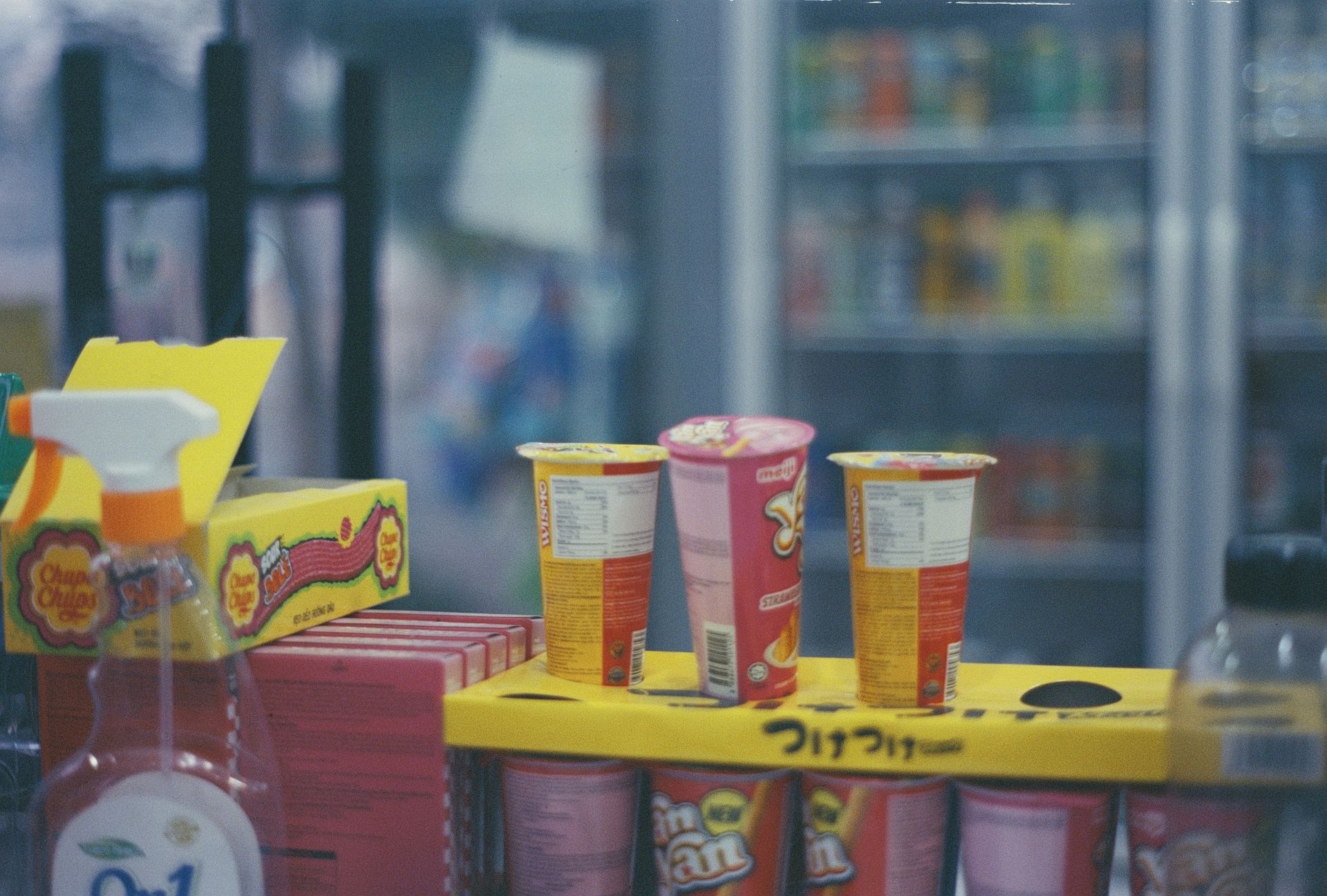 Close-up of various snacks and Yan Yan chocolate sticks in a convenience store setting.