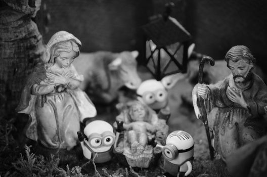 A playful black and white nativity scene combining traditional and modern figures.