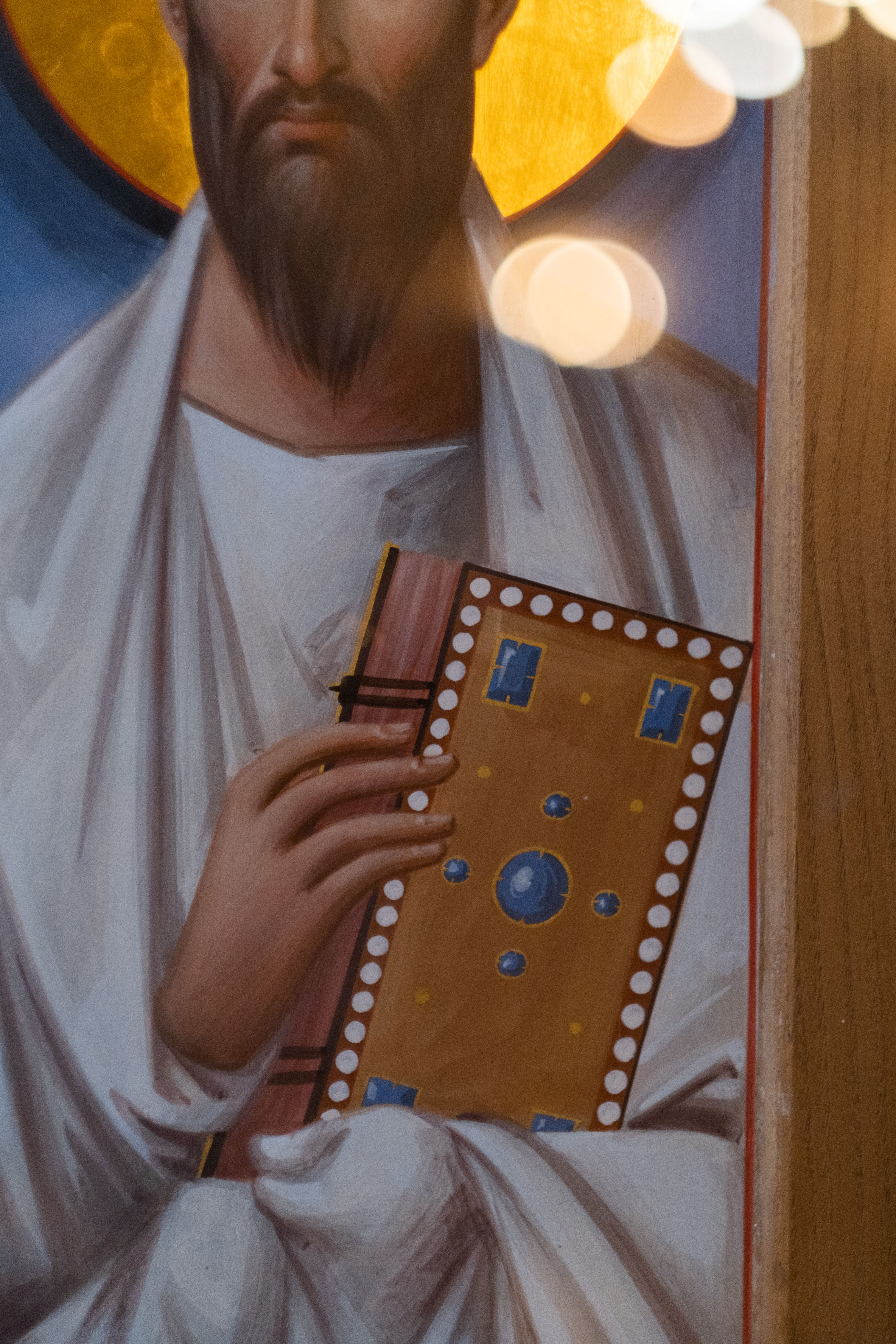 A close-up of an Orthodox religious icon featuring a figure holding a decorated book.