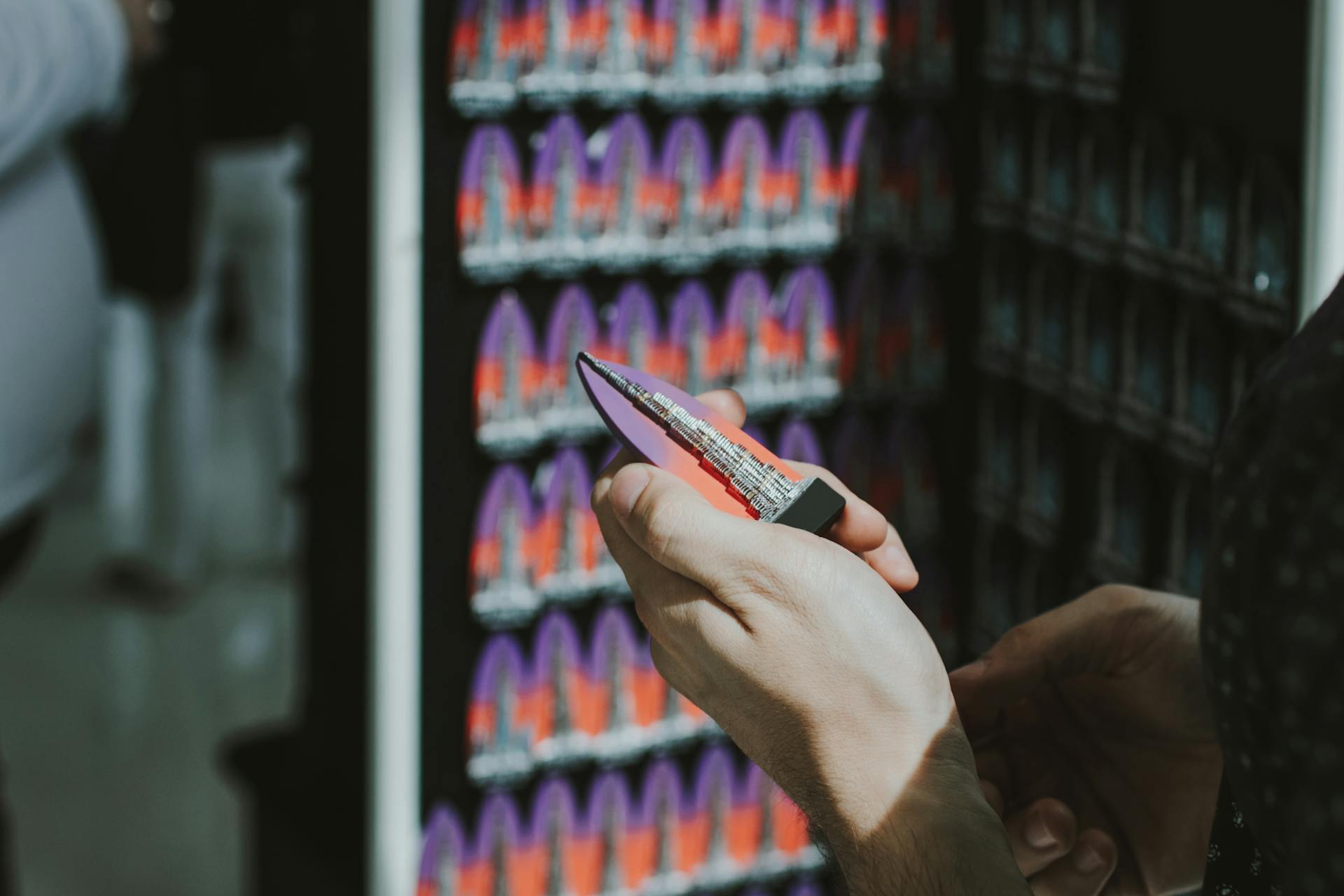 Close-up of hands holding a Burj Khalifa souvenir fridge magnet in a Dubai shop.