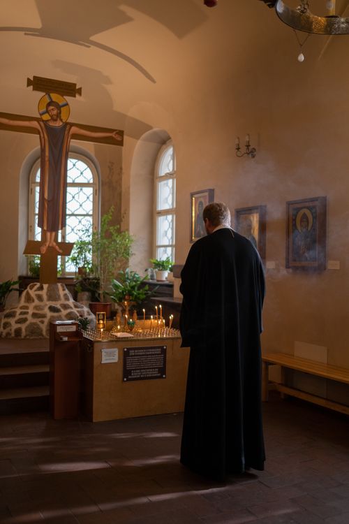 Free A priest prays quietly in a candlelit chapel, creating a peaceful and spiritual atmosphere. Stock Photo