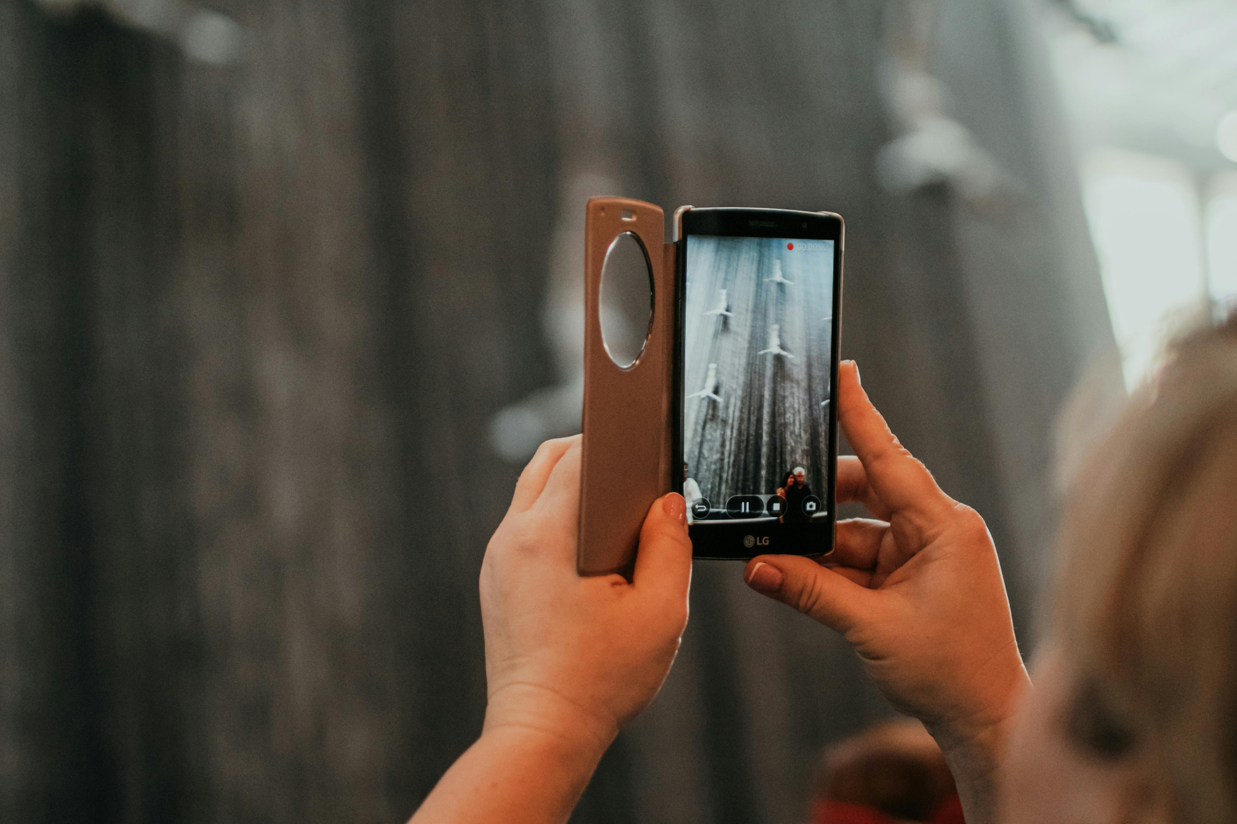 person holding iphone with brown case