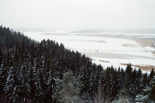 Free Aerial view of a snow-covered forest and frozen lake in Karelia, Russia during winter. Stock Photo