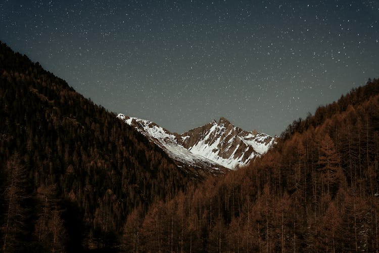 Stars On Sky Over Snowcapped Mountain