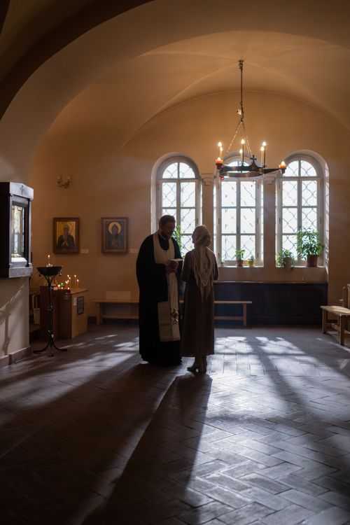 Free Quiet conversation between a man and woman in traditional robes inside a historic religious building. Stock Photo