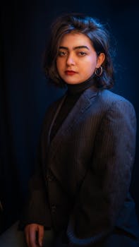 A sophisticated portrait of a woman wearing a formal suit, captured with dramatic lighting.