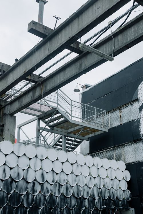 Free A vertical shot of industrial stairs and steel barrels in an outdoor setting. Stock Photo