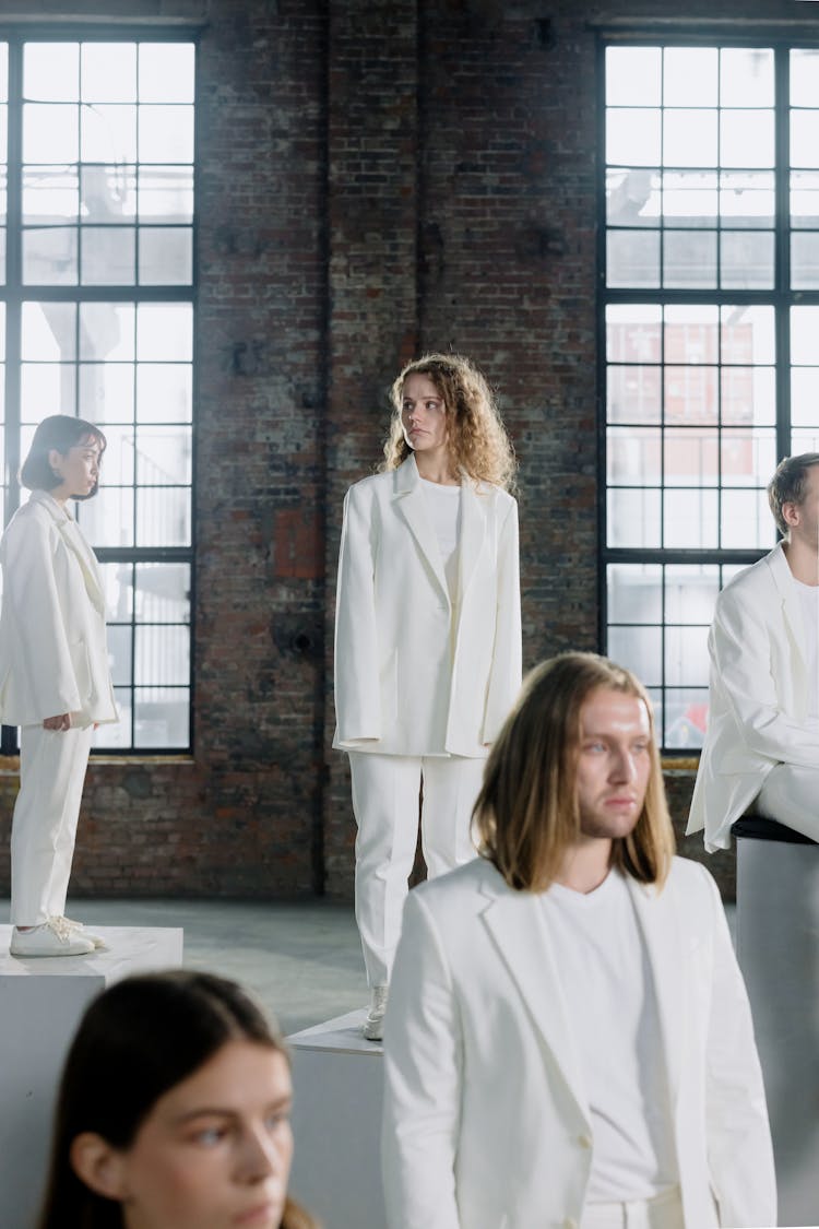 Performers Wearing White Coats Standing On Wooden Platforms