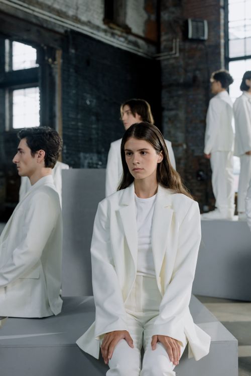 Free Fashion models pose in a striking industrial setting with modern white attire. Stock Photo
