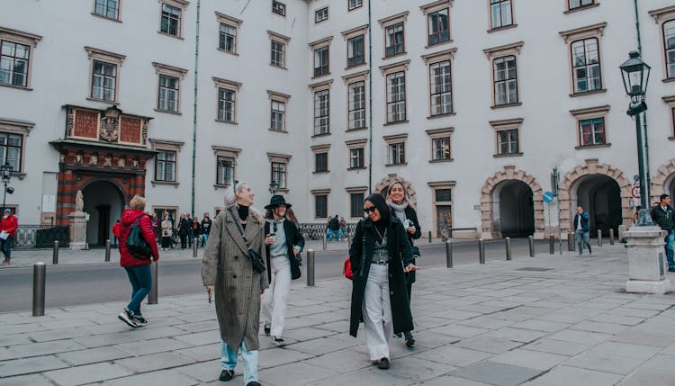 A Group Of Friends Walking On The Street While Having Conversation