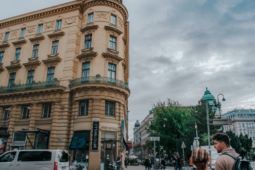 Iconic Vienna streetscape with pedestrians and historic architecture on a cloudy day.