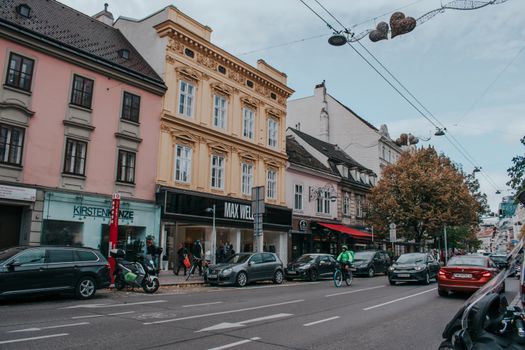 Busy urban street in Vienna with cars, cyclists, and classic architecture, showcasing city life.