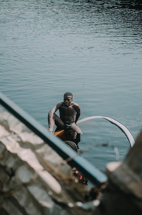 Man Sitting on Canoe on River