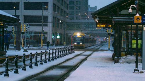 Free A tram moves through a snowy city center during winter, capturing urban infrastructure. Stock Photo