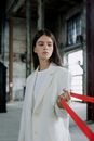 Woman in White Suit holding a Red Ribbon