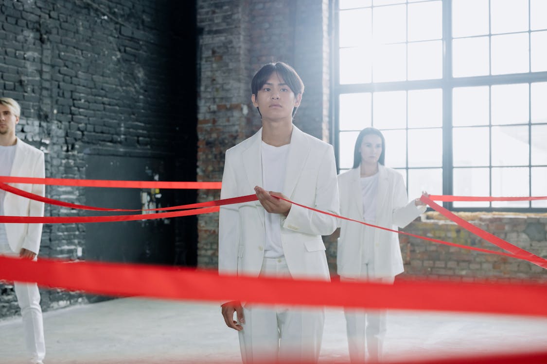 Man and Woman Holding Red Ribbon