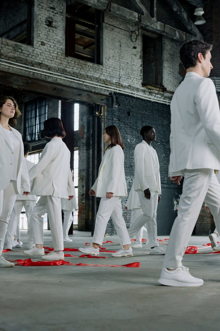 People In White Outfit Walking Inside A Building