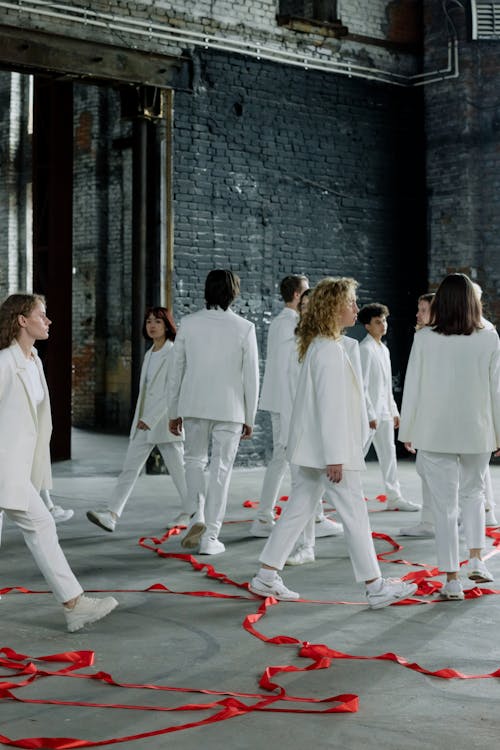 Group of People in White Clothes walking pass each other