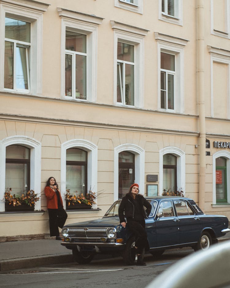 People Standing Near Retro Car On City Street