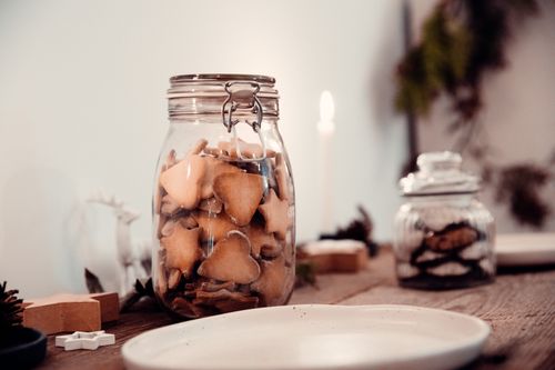Free Festive homemade biscuits in a jar on a wooden table, creating a cozy holiday ambiance. Stock Photo