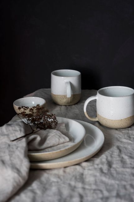 Elegant ceramic cups and plates in a minimalist style with neutral tones and light contrast.