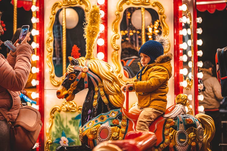 Child Riding A Carousel