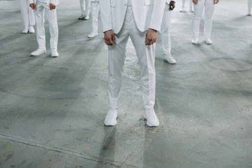 Legs of Models Standing in White Suits