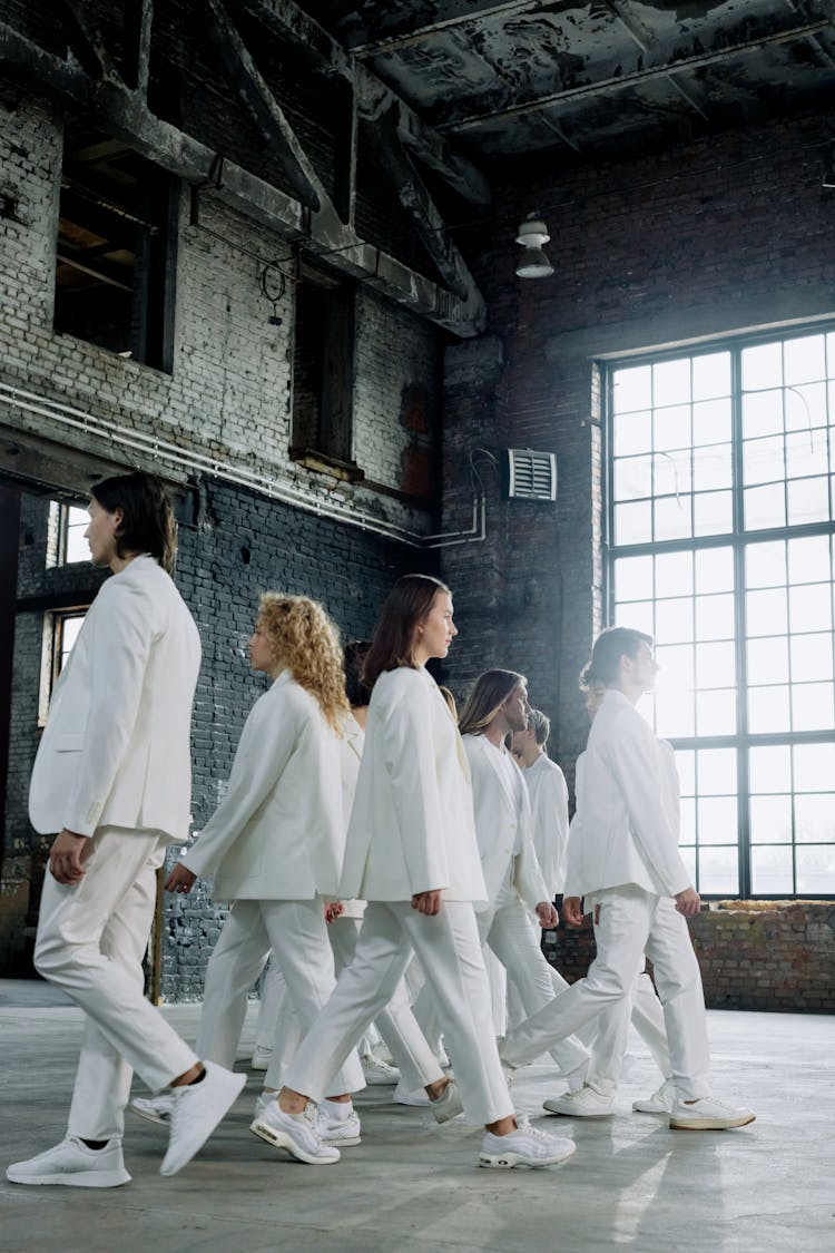 A Group Of People In White Clothes Walking