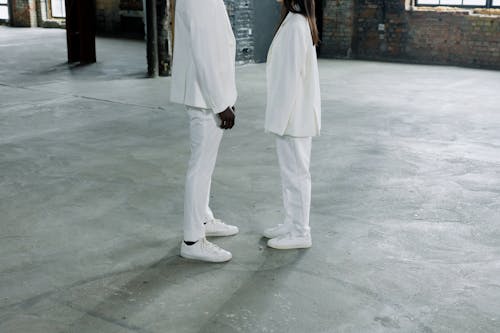 Two People in White Clothing standing in front of each other 