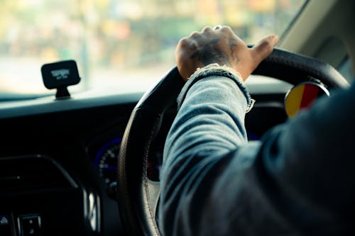 A Person in Denim Jacket Driving a Car