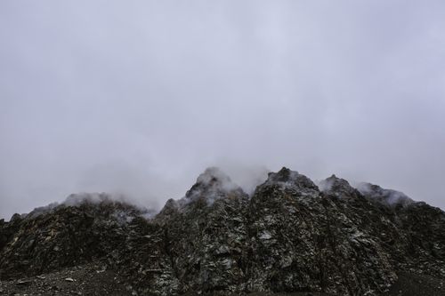 Free Moody view of rugged mountain peaks shrouded in clouds, offering a dramatic landscape scene. Stock Photo
