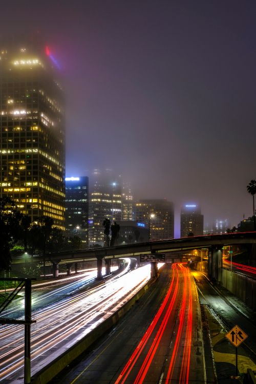 Free Foggy city night scene with dynamic light trails and illuminated skyscrapers. Stock Photo