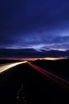 Streaks of light from cars on a highway during a long exposure shot at dusk.