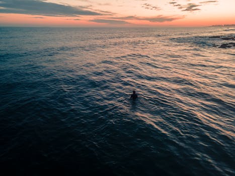 A lone swimmer enjoys the tranquil ocean at sunset in Punta del Este, Uruguay.