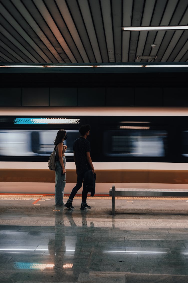 Couple Near Train In Motion In Subway