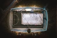 People Playing on Snow on Stadium at Night