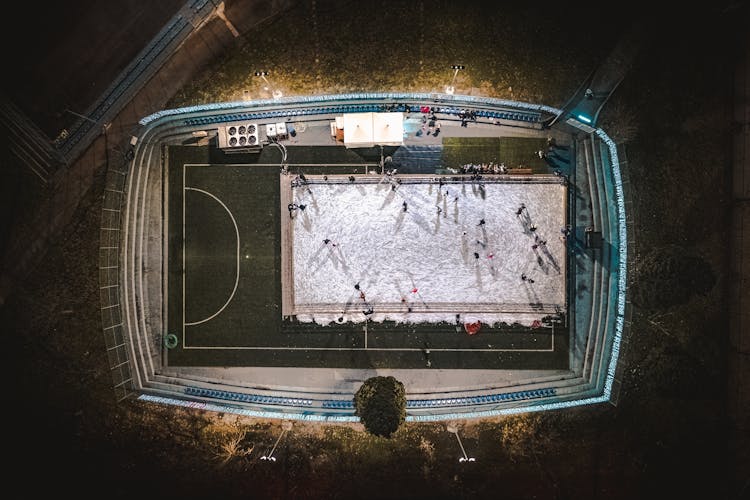 People Playing On Snow On Stadium At Night