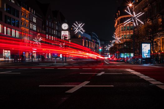 Vibrant long exposure of a bustling Hamburg street at night with colorful lights and festive decorations.